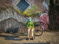 An old woman sunbathing in a fishing village in Tambaklorok, Semarang, Central Java Province, Indonesia on July 21, 2021. (