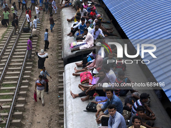 People travel on a train leaving for their hometowns for the upcoming festival Eid-ul-Fitre at the Airport Railway Stationin Dhaka on 14th J...