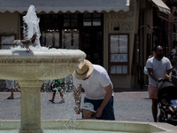 People are walking in the center of Chania, Greece during rising temperatures, passing next to the fountain on July 22, 2021.  (