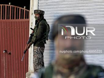 Security forces stand alert near the Gunfight site after an encounter broke out in Warpora area of Sopore between Security forces and Milita...
