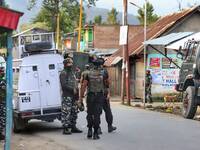 Security forces stand alert near the Gunfight site after an encounter broke out in Warpora area of Sopore between Security forces and Milita...