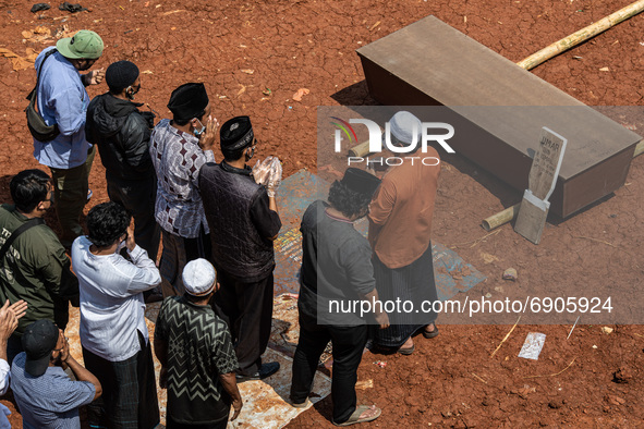 An Imam leads a prayer in front of the coffin of the Covid-19 corpse before being buried, in Banten, South Tangerang, Indonesia, on July 26,...