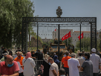Supporters of the Islamist party Ennahdha stand in front of the Tunisian parliament gate during a sit-in protest led by the Tunisian Parliam...