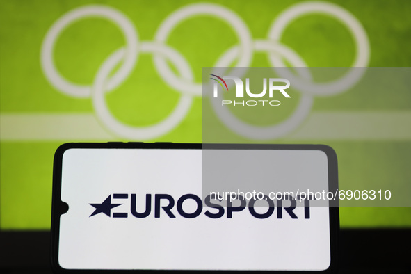 Eurosport  logo is displayed on a mobile phone screen photographed with Olympic rings symbol on the background for illustration photo. Leszc...