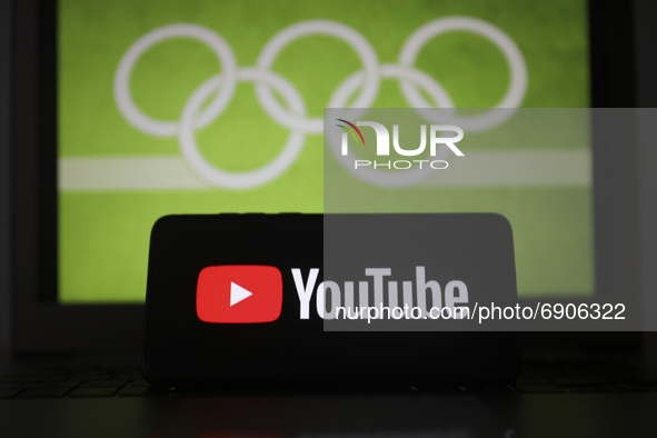YouTube  logo is displayed on a mobile phone screen photographed with Olympic rings symbol on the background for illustration photo. Leszcze...