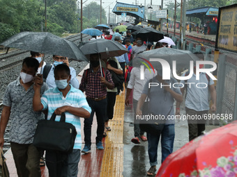 Commuters  wading through the a platform after arriving in a special service train during heavy rainfall and  ongoing COVID-19 Pandemic in K...