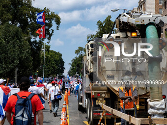 A construction worker watches as thousands of demonstrators march from the White House to the Cuban Embassy in Washington, D.C. on July 26,...