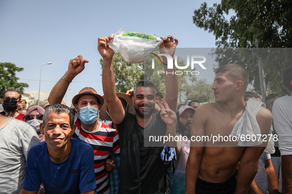 Supporters of Kais Saied raises a baby diaper as they rallied in front of the building of the Tunisian parliament in Bardo, in the capital T...