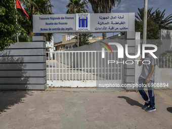 A man walks past a closed door of a public building of an office of the ministry of finance in Ariana city, near the capital Tunis, Tunisia...