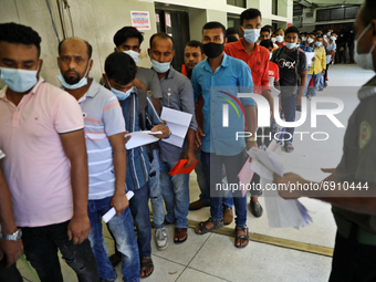 Migrant workers wait in a queue to receive a dose of the Moderna vaccine against the Covid-19 coronavirus in Dhaka, Bangladesh on July 27, 2...