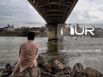 A boy watches as Water Level increases after Fresh Rainfall in Sopore, District Baramulla Jammu And Kashmir, India on 28 July 2021. 4 dead,...