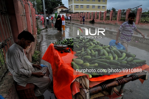 A Vegetable vendor selling cucumbers waits for customers amid rainfall in Sopore, District Baramulla Jammu And Kashmir, India on 28 July 202...