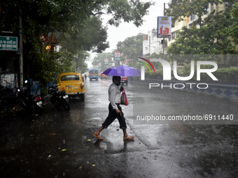 A man with his umbrella crosses a road during heavy rainfall in Kolkata, India, 28 July, 2021.  (
