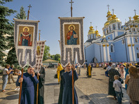 Priests with religious banners near the St. Michael's Golden-Domed Monastery wait for the beginning of the celebrations of the Day of Baptis...