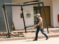 a man walks pass a destroyed bus stop in Stolberg, Germany on July 28, 2021 (