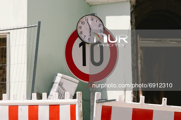 a clock is seen stopped on top pf a traffic speed sign in Stolberg, Germany on July 28, 2021 