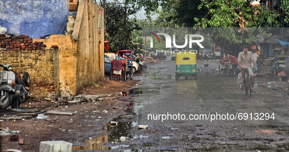 Man rides a bicycle down a run-down area of Delhi, India, on July 08, 2010. 