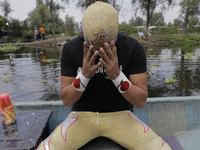 Gran Felipe Jr., a professional wrestler, aboard a boat as he adjusts his mask before a wrestling match where he goes head to head with othe...