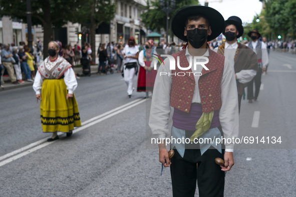 a group of people parade with regional costumes from Cantabria, through the streets of Santander to commemorate the Day of Institutions, whi...