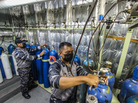 Indonesian Navy officers fill oxygen cylinders in the warship KRI dr Soeharso-990 which docks at the Tanjung Emas port, Semarang, Central Ja...