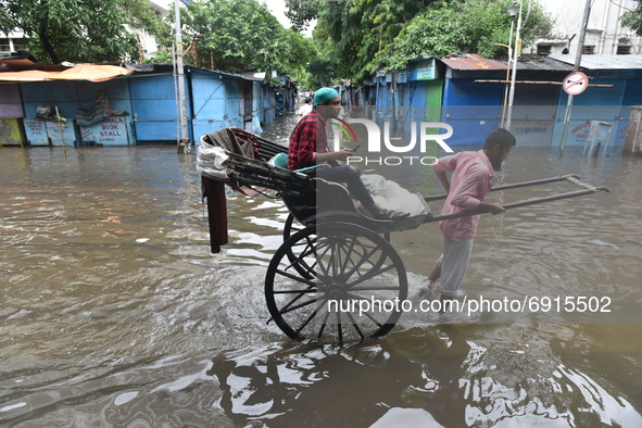 A hand pulled rickshaw is seen waded through a waterlogged street in Kolkata, India, on July 30, 2021. 