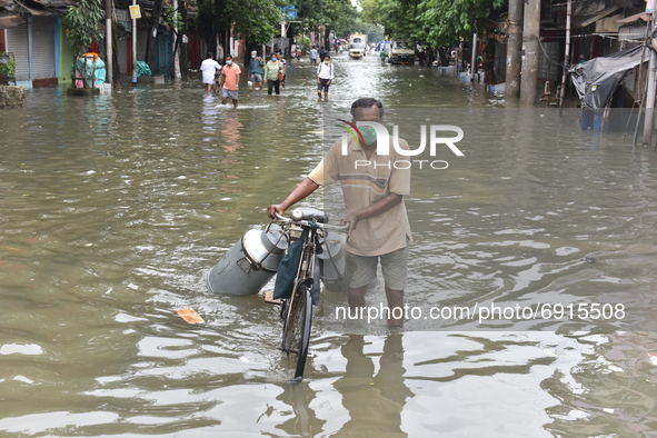 A milkman wades through a waterlogged street  in Kolkata, India, on July 30, 2021. 