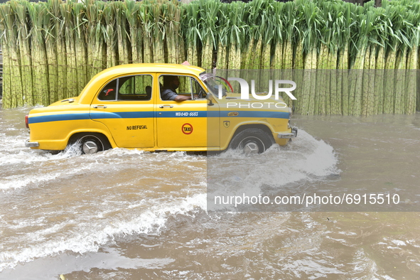 A taxis wade through a waterlogged street in Kolkata, India, on July 30, 2021. 