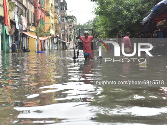 A hand pulled rickshaw is seen waded through a waterlogged street in Kolkata, India, on July 30, 2021. (