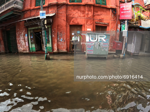 A man look on newspaper at the front  a flooded Street at the Heavy monsoon rains in Kolkata on July 30,2021. 