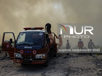 Members of the Regional Disaster Management Agency (BPBD) Ogan Ilir and members of the Indonesian National Army extinguish peatland fires in...