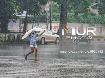 A man covers with polythene to protect himself as he walks during the rainfall in Dhaka, Bangladesh on July 31, 2021 (
