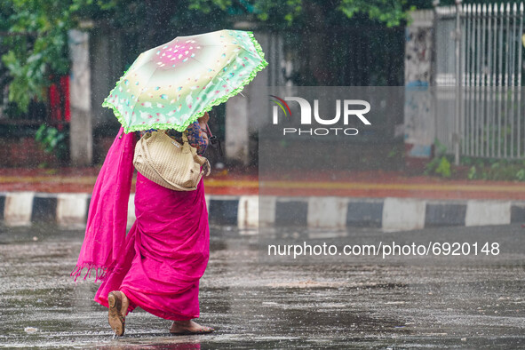 A woman holding an umbrella as she walks during the rainfall in Dhaka, Bangladesh on July 31, 2021. 