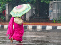 A woman holding an umbrella as she walks during the rainfall in Dhaka, Bangladesh on July 31, 2021. (