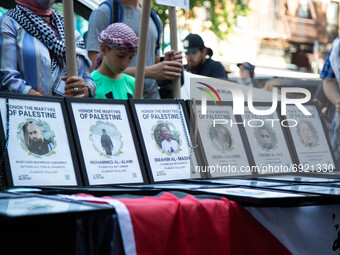 Pictures of victims are displayed as people demonstrate in support of Palestine in Brooklyn, New York, US on July 31, 2021.  (
