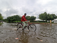 A commuter wade through a waterlogged street on a rainy day during the monsoon season , in Jaipur, Rajasthan, India, Monday, Aug 02,2021. (