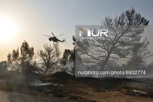 Vaimpompi, Greece. August 4th, 2021. A firefighting helicopter sprays water to contain a wildfire in the northern Athens suburb Varimpompi,...