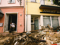 a helper cleans up the a store in Bad Neuenahr-Ahrweiler, Germany on August 4, 2021 as two weeks after flood disaster (