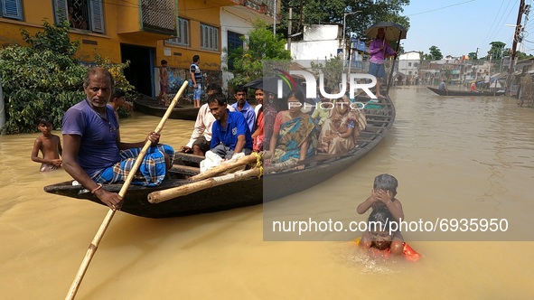 A Women with her Children under the  floodwaters and  flood victims on a boat make their way through flood waters after collecting relief ma...
