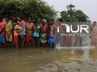 An Indian resident  waiting up to receive relief material provided by the State government  in floodwaters at Amta-2 in the Howrah district...
