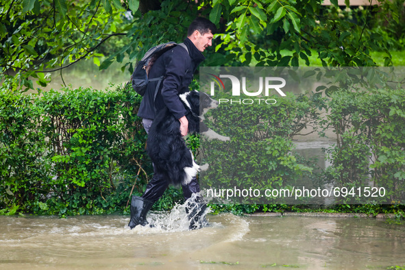A man carries his dog after streets and households areas of Bierzanow district were flooded with heavy rain shower in Krakow, Poland on Augu...