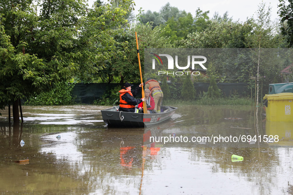 Firefighters are swimming on a boat after streets and households areas of Bierzanow district were flooded with heavy rain shower in Krakow,...