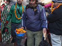 Nepali Hindu man carries a rooster that had just been sacrificed to the Goddess Kali at the Dakshinkali Temple in Nepal, on December 13, 201...