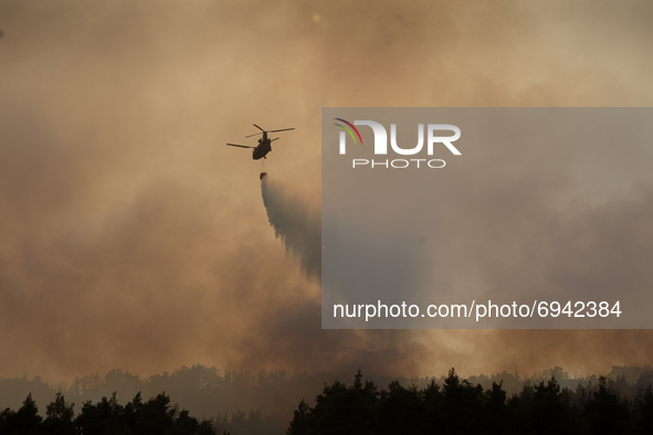 A firefighting helicopter releasing buckets of water during the wildfires in  Evia, Greece, on August 5th, 2021. 