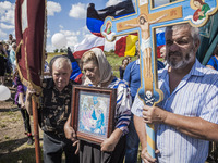Visitors with holy crosses and religious icons visit the place where the malaysian flight MH17 fell in the Hrabove village, Ukraine,  during...