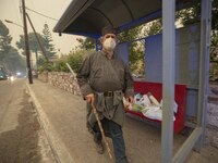 A man walks in the Pefki village, in Evia Island, Greece, on August 8, 2021. The European Union announced that it would be sending aid to Gr...