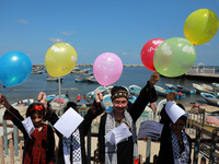 Palestinian children release balloons during a protest against the blockade on Gaza at the port of Gaza City on August 10 , 2021.  (