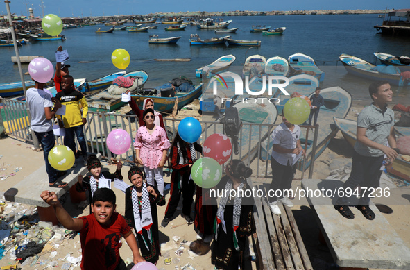 Palestinian children release balloons during a protest against the blockade on Gaza at the port of Gaza City on August 10 , 2021.  
