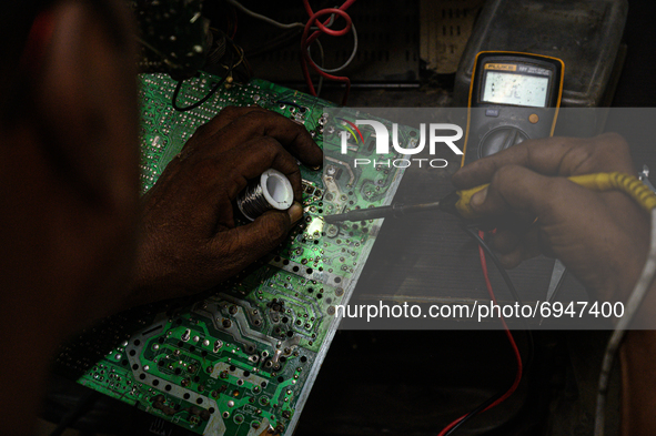 A television mechanic is repairing a printed circuit board (PCB) of the TV in Tehatta, West Bengal; India on 10 August 2021. According to th...
