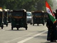A woman sells Indian national flags along a road, ahead of India's 75th Independence day celebrations, in New Delhi, India on August 13, 202...