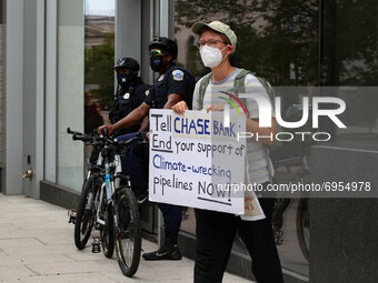 Demonstrators with the organization Climate First! protest outside of several branches of major banks on August 13, 2021 in Washington, D.C....